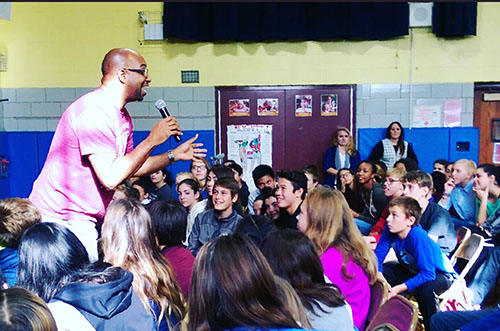Author Kwame Alexander talking to students at a school