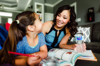 Mom and daughter practice healthy hydration by drinking Nestlé Water.