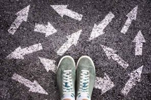 how to pick the right college - Sneaker shoes and arrows pointing in different directions on asphalt ground, choice concept