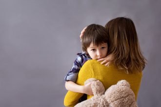 Manage anxiety: Sad little child, boy, anxiety, hugging his mother at home