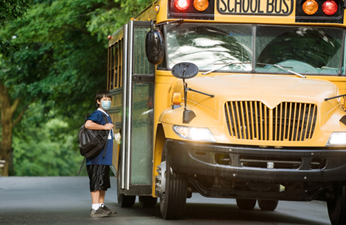 Reduce Germ spread: Boy in mask at school bus