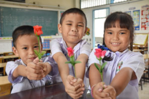 Kids giving teacher flowers