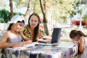 5 tips to having fun with Kids while WFH - Woman Working Outdoors In The Park With Her Little Daughters Using Laptop Computer