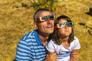 Father and daughter looking at eclipse