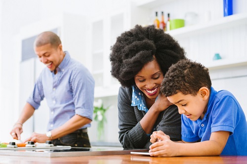 Mixed Race Family in the kitchen cooking and using digital tablet.