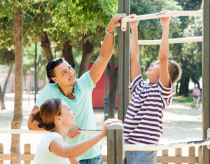 Family of three training on chin-up bar